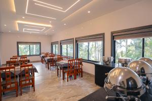 a dining room with tables and chairs and windows at Rippon Mount Resorts in Meppādi