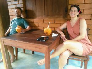 a man and a woman sitting at a wooden table at Lunuvila Resort Hiriketiya Dikwella in Dickwella