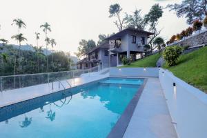 a swimming pool in front of a house at Rippon Mount Resorts in Meppādi