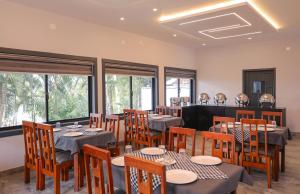 a dining room with tables and chairs and windows at Rippon Mount Resorts in Meppādi