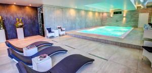 a large swimming pool in a room with chairs at Rekreačné domy Marina Cabin House in Bobrovník