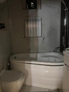 een badkamer met een wit bad en een toilet bij Royal in Osh