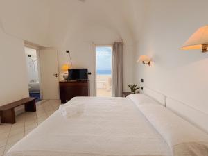 a bedroom with a bed and a view of the ocean at Mursia Wellness Hotel in Pantelleria