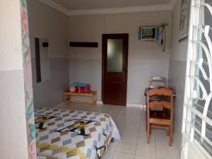 ein Schlafzimmer mit einem Bett und einem Stuhl in der Unterkunft Rem Hotel in Fianarantsoa + 5 Fotos