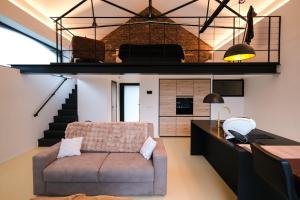 ein Wohnzimmer mit Sofa und Treppe in der Unterkunft La Forge in Wanze
