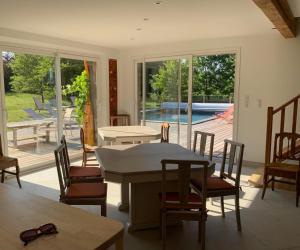 a dining room with a table and chairs and a patio at En joía ! in Teyssode