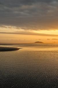 a sunset over the water with the horizon at Harrington Holiday House in Harrington