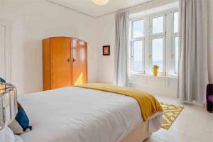 een witte slaapkamer met een bed en een raam bij Dairsie Sea View in Rothesay