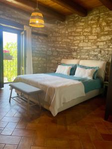 a bedroom with a large bed and a stone wall at Casale le Fontanelle in Monte Grimano Terme