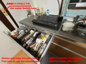 a kitchen with a sink and a counter with a drawer at 古民家宿Step inn Hagi なかつえ in Hagi