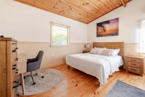 a bedroom with a bed and a desk and a computer at Bonnie Brae Retreat in Swansea