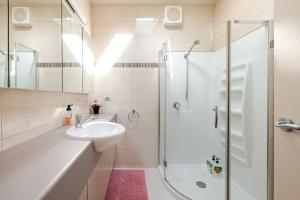 a white bathroom with a sink and a shower at Bonnie Brae Retreat in Swansea +68 photos