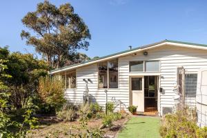 a white house with the front door open at Bonnie Brae Retreat in Swansea
