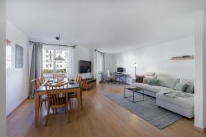 een woonkamer met een tafel en een bank bij Chasa Valbernard 4105 in Vulpera