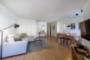 een woonkamer met een witte bank en een tafel bij Chasa Valbernard 4105 in Vulpera