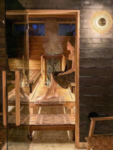a woman sitting on the stairs of a sauna at Butikowe apartamenty w Sudetach - TRZY MORZA - pod górą Trójmorski Wierch in Jodłów