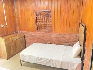 a bedroom with a bed and a brick wall at The Thinnai Farm in Jaffna +9 photos