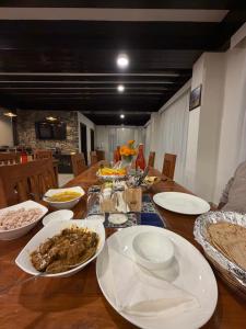 a wooden table with plates of food on it at Manali Se - Your Home in the Pines in Jagatsukh +28 photos