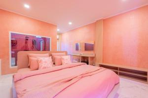 una camera da letto con un letto grande con lenzuola rosa di บ้านพวงชมพูเกาะล้าน a Ko Larn Altre 28 foto