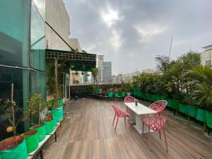 balcone con tavolo, sedie e piante di Penthouse a Noida