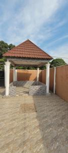 a gazebo with a red roof on a patio at BTourays Rentals in Yundum