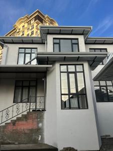 een wit huis met een balkon en een gebouw bij Royal in Osh