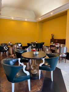 a restaurant with tables and chairs and yellow walls at Loft de Mérilen - Dentro do Palácio Quitandinha in Petrópolis