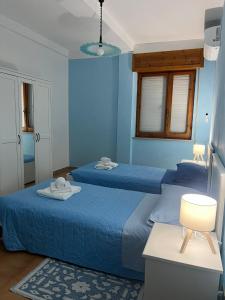 twee bedden in een kamer met blauwe muren bij alta marea sardegna in Portoscuso