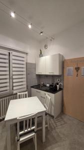 a kitchen with a white table and a table and chairs at SantegidioHomeCesena in Cesena