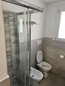 a bathroom with a toilet and a glass shower at SantegidioHomeCesena in Cesena +3 photos