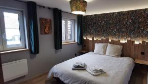 a bedroom with a bed with towels on it at L'orée du lac in Kruth +2 photos