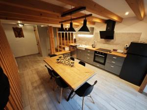 a large kitchen with a wooden table and chairs at L'orée du lac in Kruth