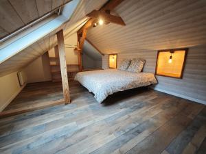 a bedroom with a bed in a wooden room at L'orée du lac in Kruth