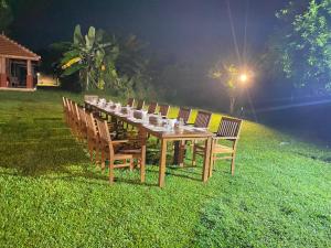 a long wooden table and chairs in the grass at The Thinnai Farm in Jaffna