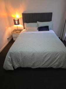 a bedroom with a large bed with a striped comforter at Four-bedroom house in Gungahlin