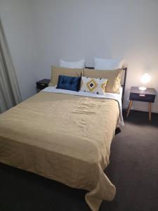 a bedroom with a large bed with pillows on it at Four-bedroom house in Gungahlin