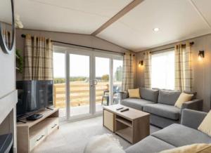 a living room with a couch and a tv at ScottishHighlands in Boat of Garten