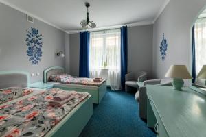 een hotelkamer met twee bedden en een bureau bij Villa Polka in Kudowa-Zdrój