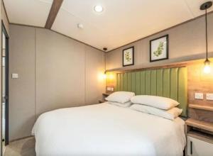 a bedroom with a large white bed with two pillows at ScottishHighlands in Boat of Garten
