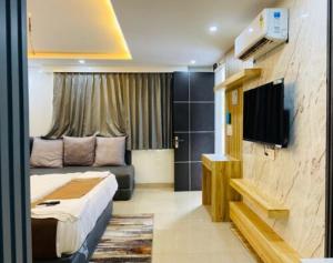 a hotel room with a bed and a flat screen tv at The Haven Studio in Dehradun