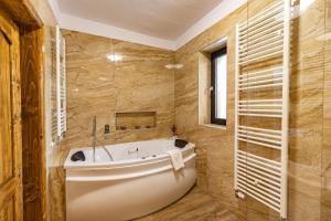 een badkamer met een bad en een raam bij Rustic Maramureș in Ocna Şugatag +38 foto's