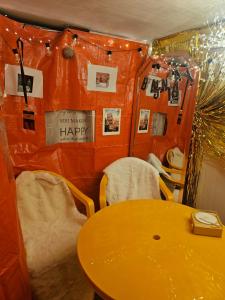 een tafel en stoelen in een kamer met oranje muren bij K-Culture Cozy House ,Hanbok & Korean Food Experience in Seoul
