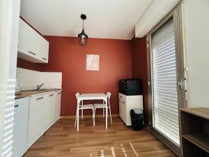 a kitchen with a table and a chair in it at Bel Air Appartement in Niort
