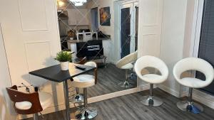 un salone con sedie bianche e tavolo di Spacious Luxurious Serviced Accommodation 5 a Bushbury
