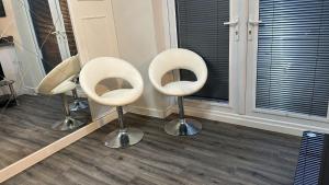 tre sedie bianche sedute in una stanza di Spacious Luxurious Serviced Accommodation 5 a Bushbury Altre 12 foto
