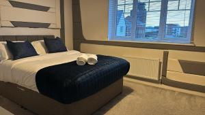 una camera da letto con un letto con due cuscini e una finestra di Spacious Luxurious Serviced Accommodation 5 a Bushbury