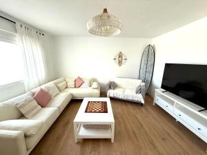 a living room with a couch and a tv at Villa Marée La Costa in La Costa