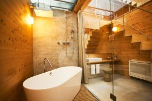 a bathroom with a bath tub and a sink at A&A Okayama in Okayama