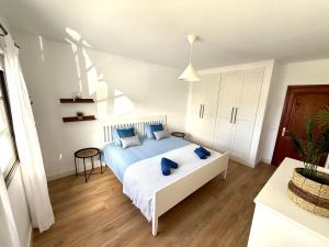 a bedroom with a bed with blue pillows on it at Villa Marée La Costa in La Costa +21 photos