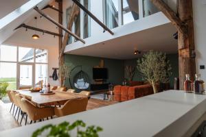 een open woonkamer met een tafel en stoelen bij B&B Lindehoeve Texel in Den Hoorn